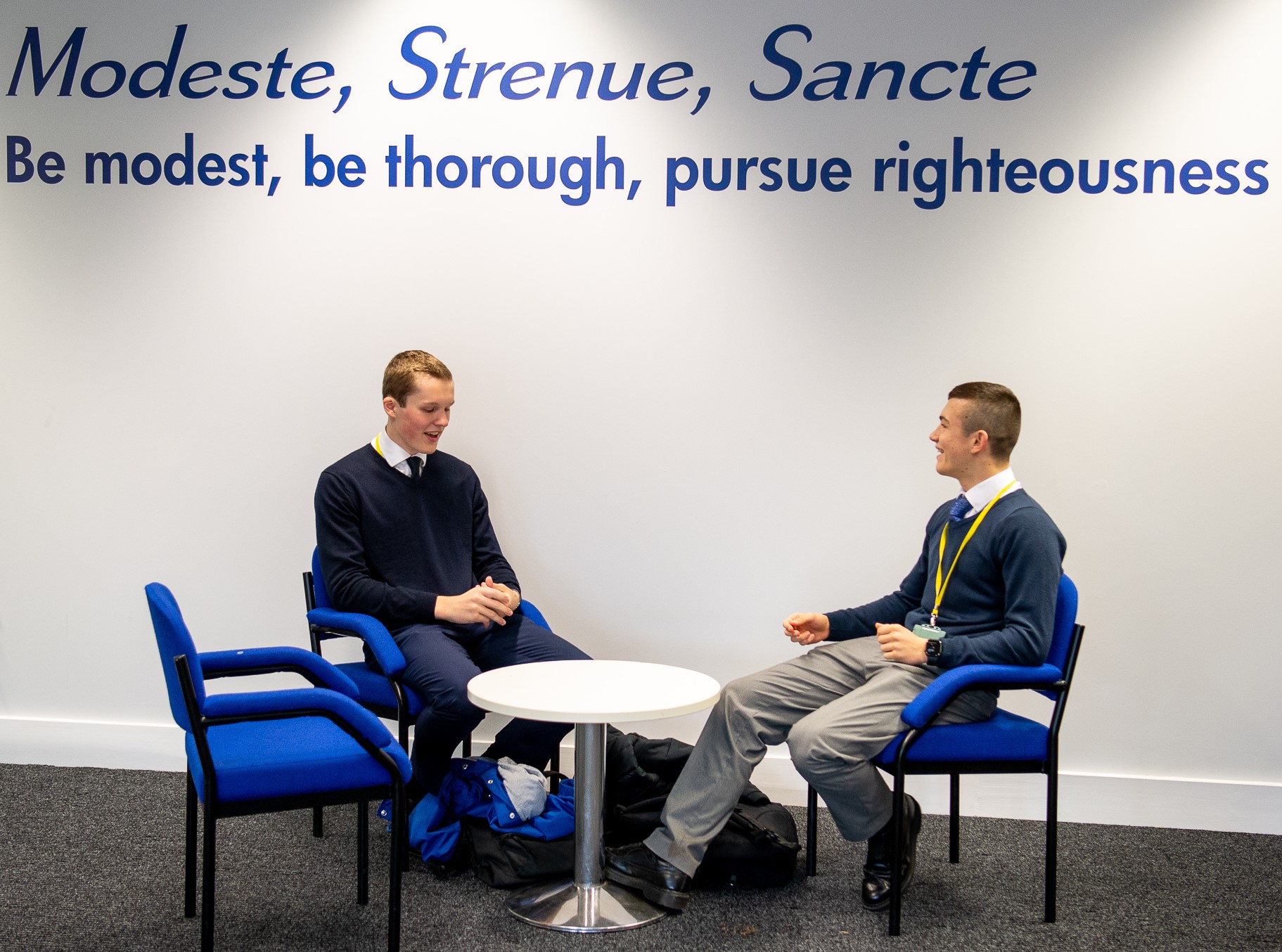 sixth form students sitting under the school motto
