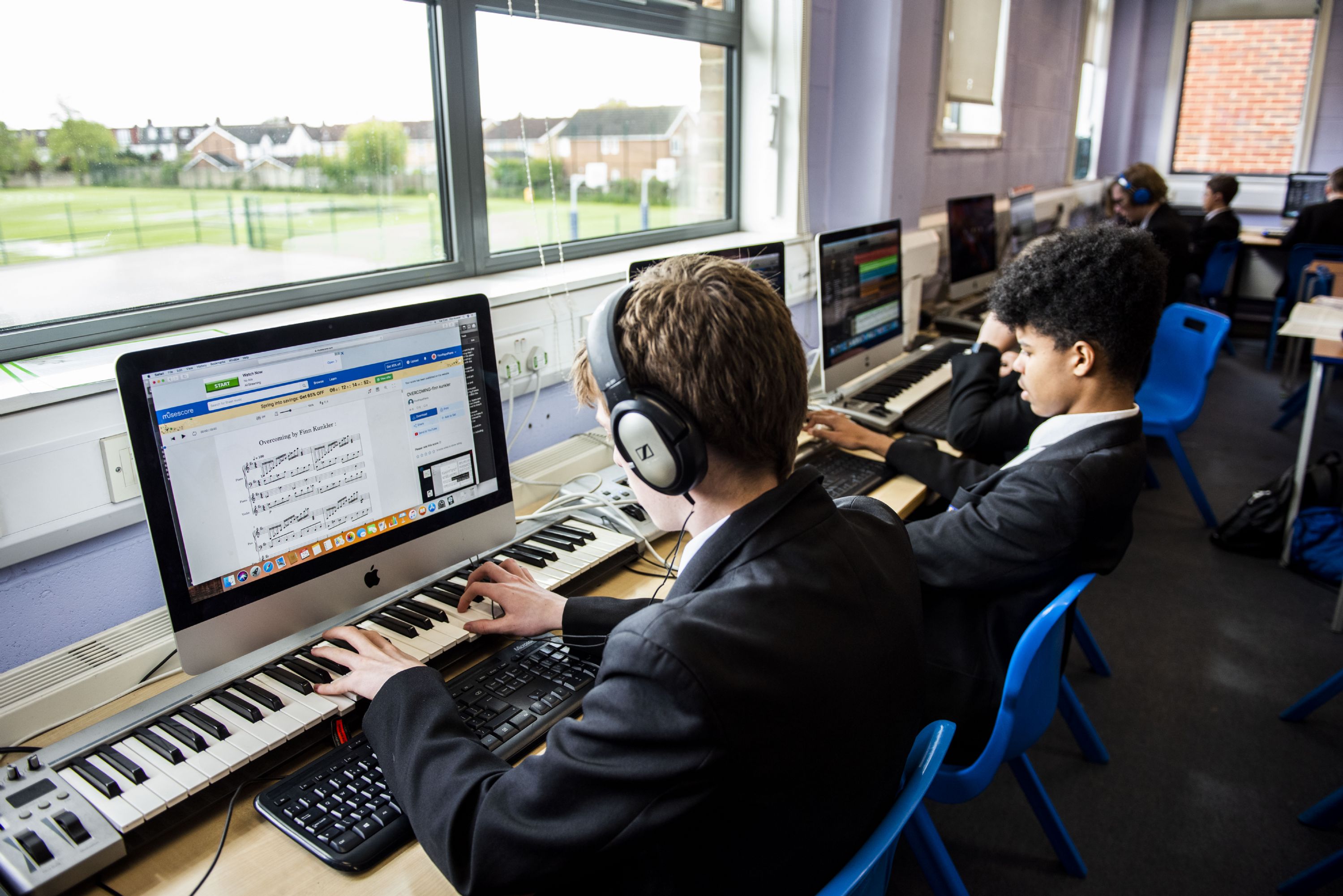 students playing keyboards in a music lesson