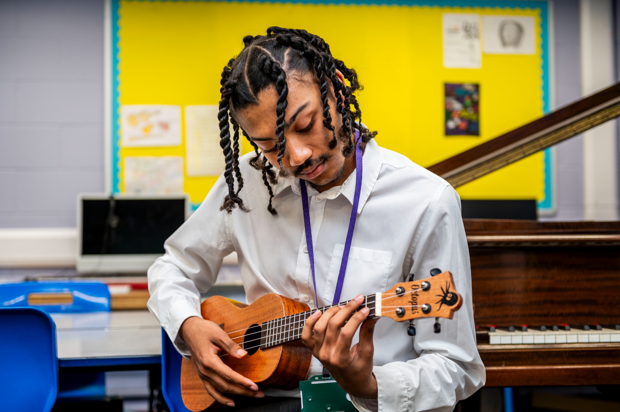 Rutlish sixth student playing the ukelele sixth form students working in the common room
