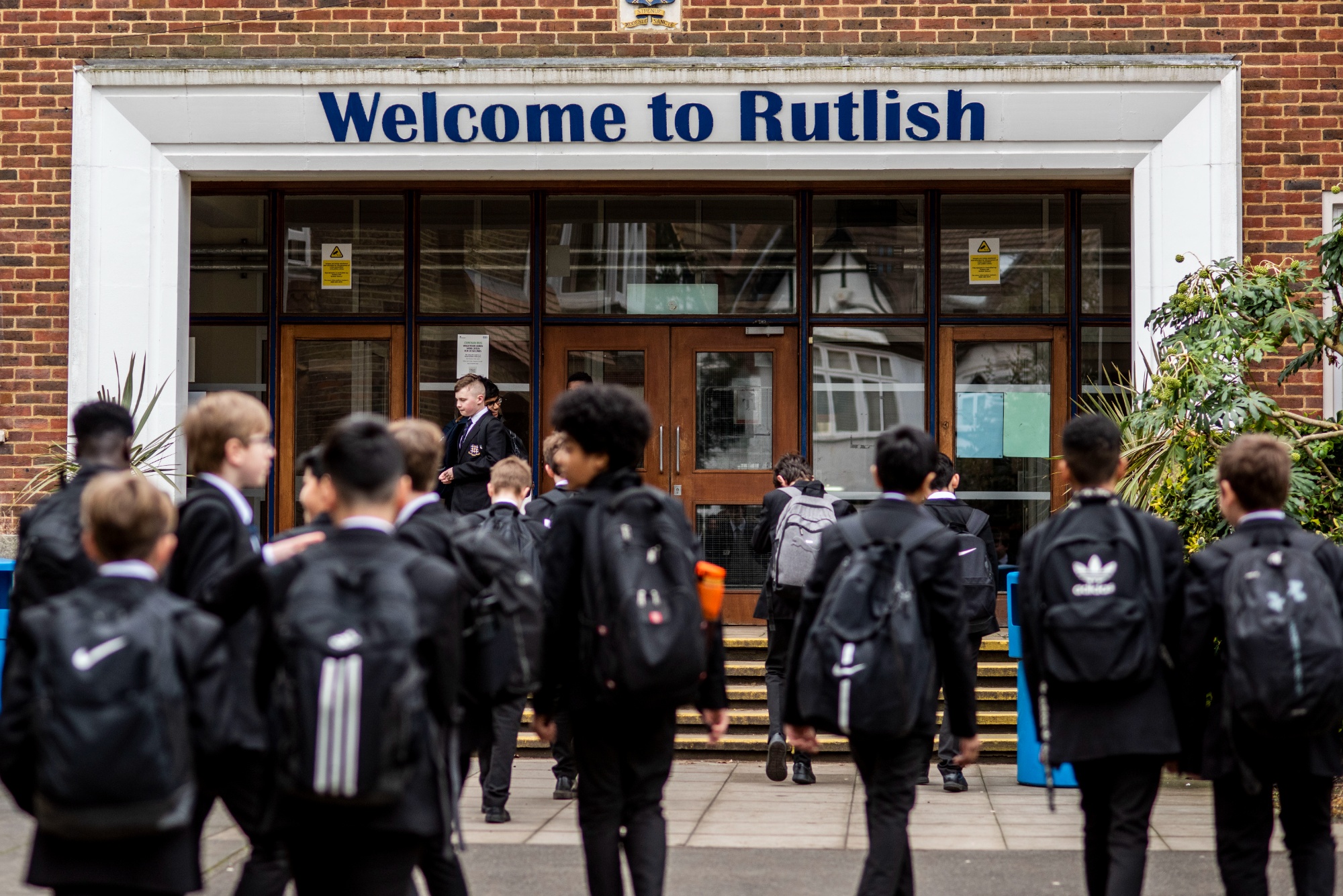 Rutlish students walking into school with the Ofsted outstanding logo